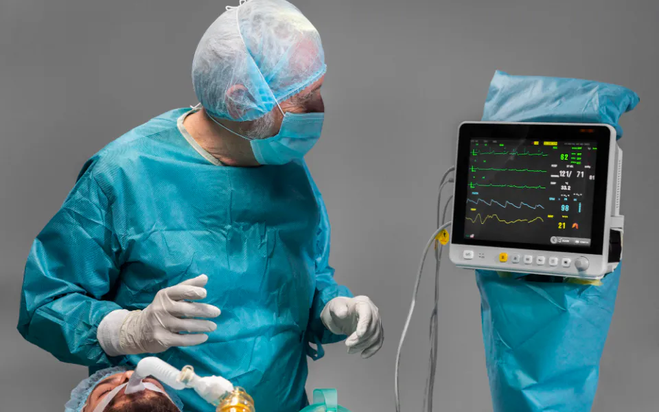 Senior doctor monitoring live heartbeat display during angiography procedure for vascular assessment.