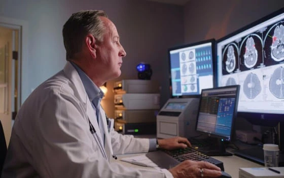 elder-radiologist-reviewing-mri-images-on-laptop.