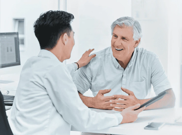 young-doctor-and-elderly-patient-at-medical-desk