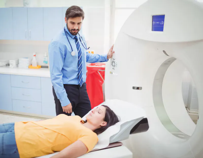 Cardiology specialist guiding patient into MRI machine for comfortable, precise cardiac imaging.