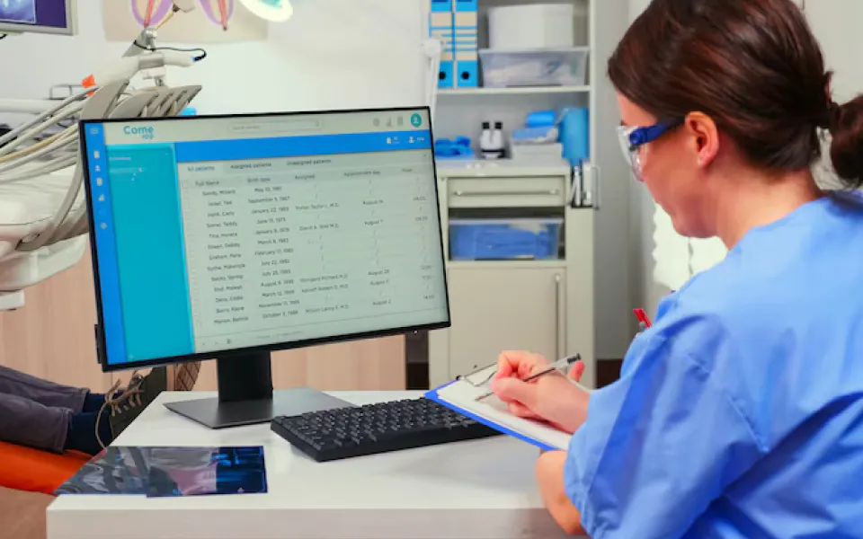 Hospital staff operating a PC screen displaying patient data