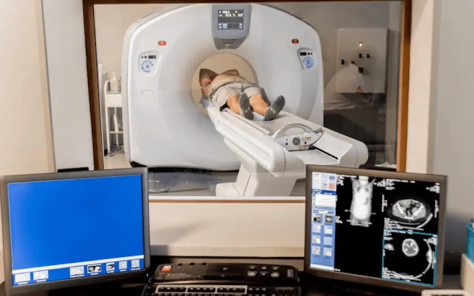 Patient undergoing MRI scan with live results displayed on a nearby screen