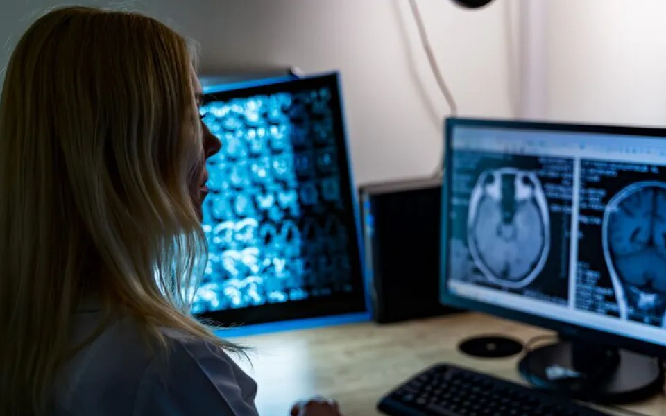 Doctor viewing two monitors displaying different head MRI scans using Scriptoware’s Medical Image Integration API.